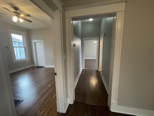 corridor featuring visible vents, dark wood finished floors, attic access, and baseboards