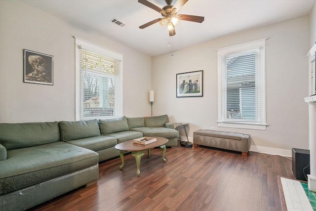 living room featuring ceiling fan, plenty of natural light, and dark wood-type flooring