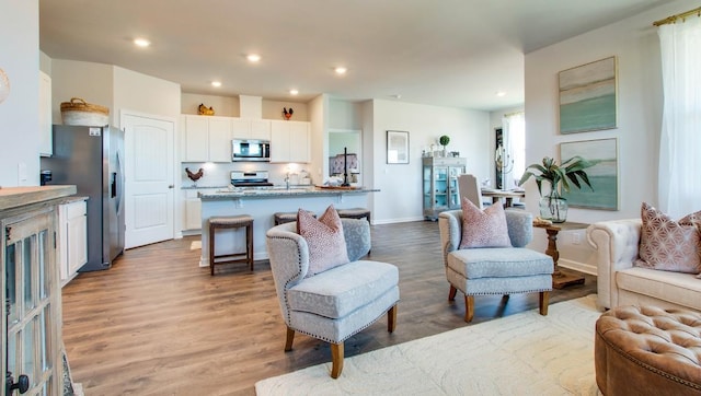 living room featuring recessed lighting, light wood-style flooring, and baseboards