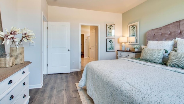 bedroom with baseboards and dark wood-type flooring