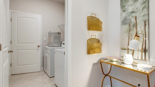 clothes washing area featuring light tile patterned flooring and washing machine and clothes dryer