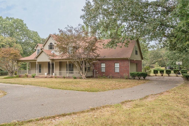 view of front of house with a porch, a garage, and a front yard