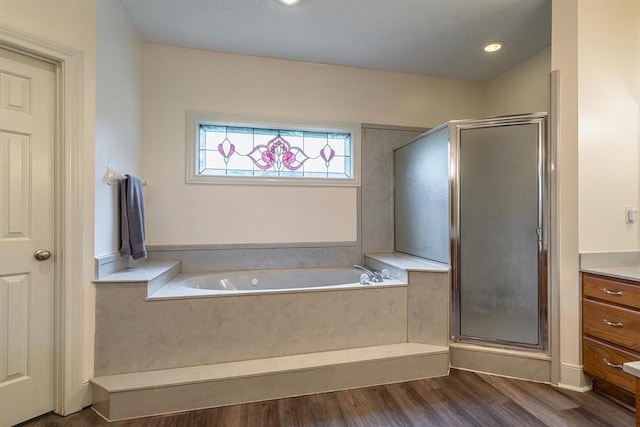 bathroom featuring hardwood / wood-style floors and plus walk in shower