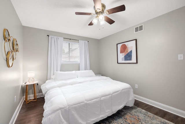 bedroom with a textured ceiling, dark hardwood / wood-style flooring, and ceiling fan