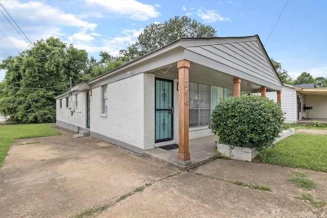 view of home's exterior with covered porch and a yard