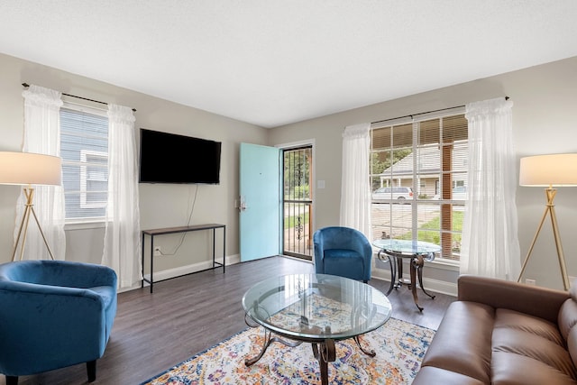 living room with plenty of natural light and dark wood-type flooring