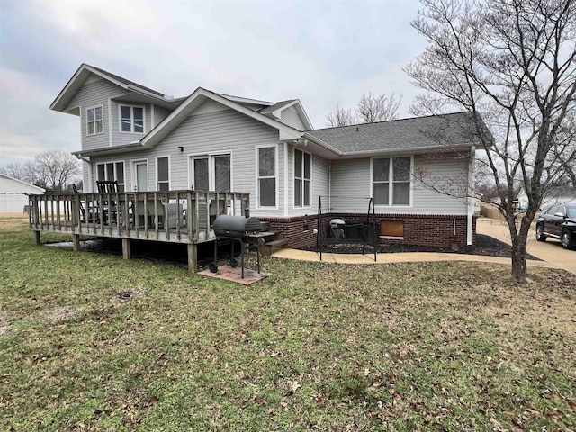 rear view of house featuring a lawn and a wooden deck