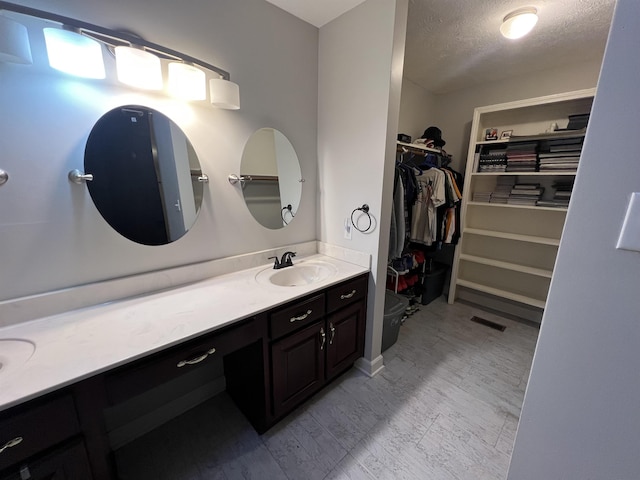 bathroom with vanity and a textured ceiling