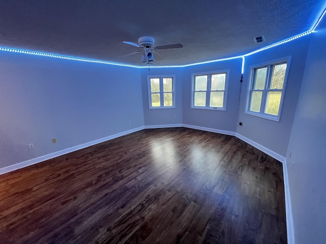 unfurnished room featuring a textured ceiling, ceiling fan, and dark wood-type flooring