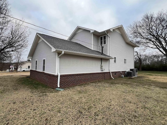 view of side of property with a yard and central AC unit