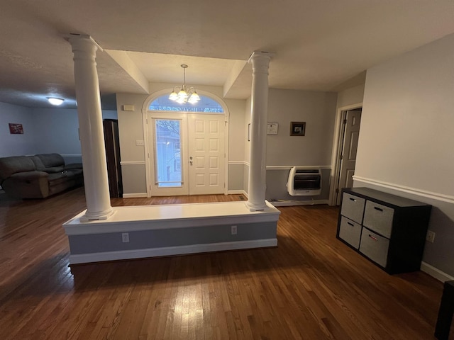 foyer entrance with a notable chandelier, dark wood-type flooring, and heating unit