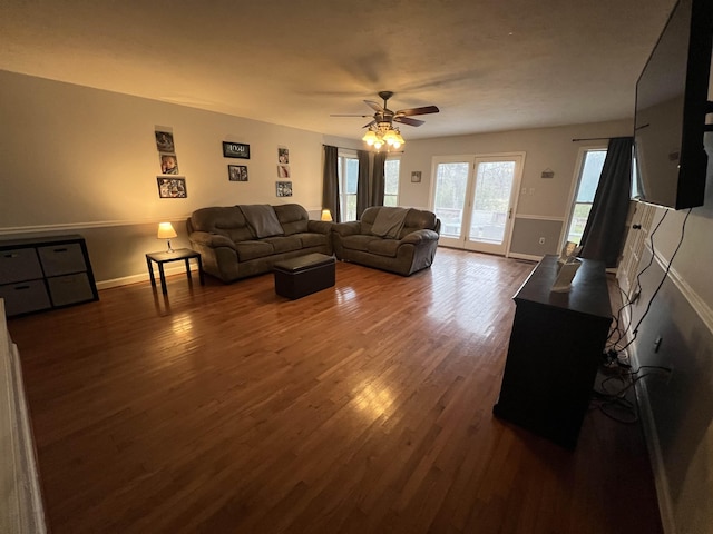 living room with ceiling fan and dark wood-type flooring