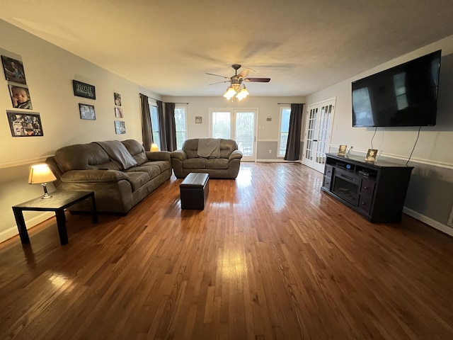 living room with ceiling fan and dark hardwood / wood-style flooring