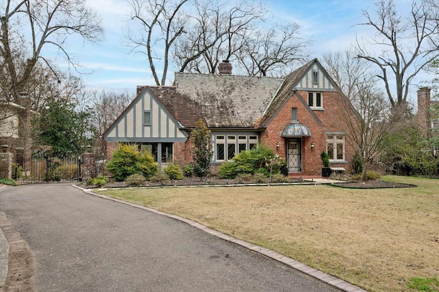 tudor-style house featuring a front yard