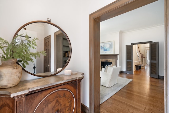 interior details with ornamental molding and hardwood / wood-style flooring