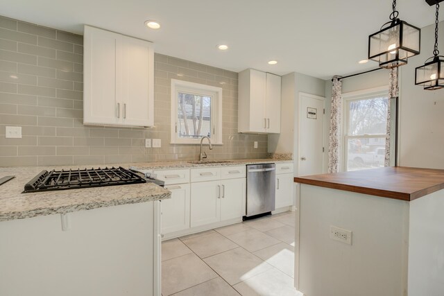 kitchen with white cabinets, appliances with stainless steel finishes, and pendant lighting