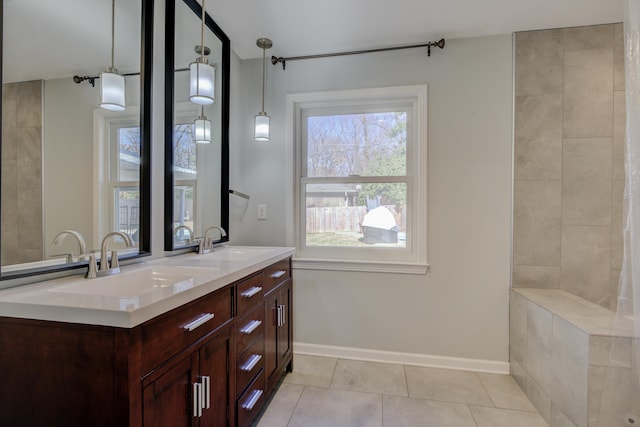 bathroom with tile patterned flooring, vanity, and a healthy amount of sunlight