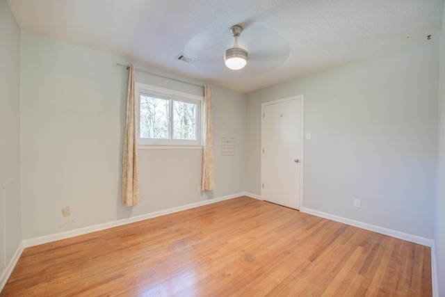 spare room featuring a textured ceiling, light hardwood / wood-style floors, and ceiling fan