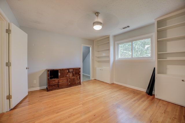 interior space featuring a textured ceiling, light hardwood / wood-style floors, and ceiling fan