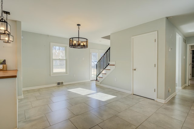 interior space with light tile patterned flooring and an inviting chandelier