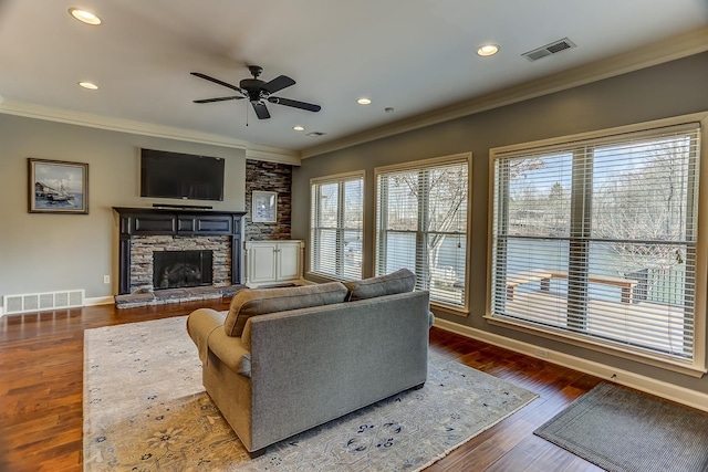 living room featuring ceiling fan, a fireplace, and ornamental molding