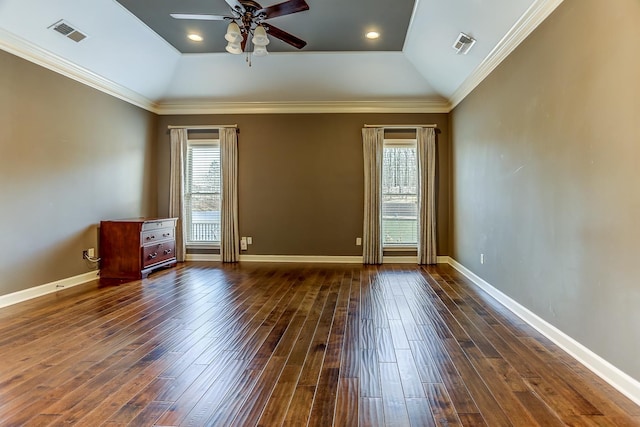 spare room featuring ceiling fan, a tray ceiling, dark hardwood / wood-style flooring, vaulted ceiling, and crown molding