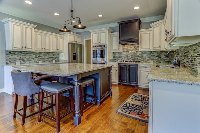 kitchen featuring a kitchen island, decorative light fixtures, stainless steel appliances, sink, and premium range hood