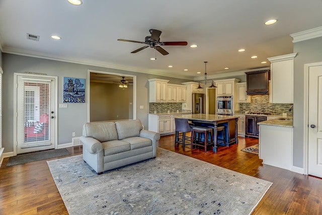 living room featuring ceiling fan, dark wood-type flooring, sink, and ornamental molding