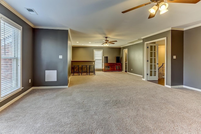 carpeted empty room with ceiling fan, ornamental molding, and french doors