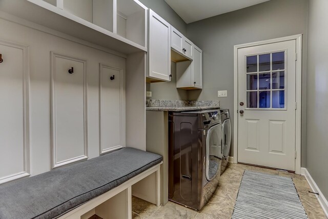 washroom featuring washing machine and clothes dryer and cabinets