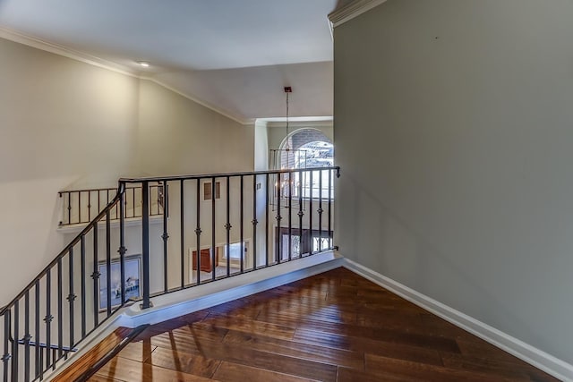 stairs with hardwood / wood-style floors, lofted ceiling, crown molding, and an inviting chandelier