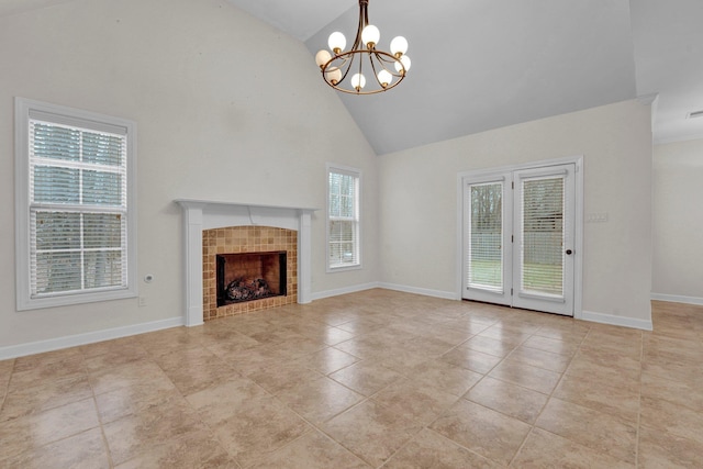 unfurnished living room with a fireplace, light tile patterned floors, high vaulted ceiling, and a notable chandelier