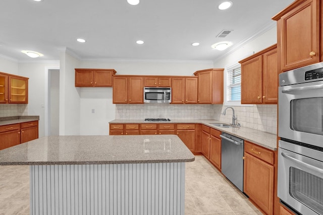 kitchen featuring stainless steel appliances, a kitchen island, ornamental molding, and sink