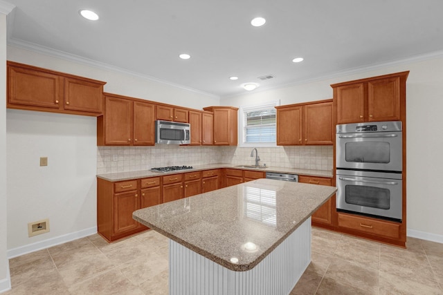 kitchen with sink, light stone countertops, ornamental molding, a kitchen island, and stainless steel appliances