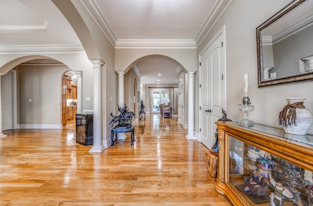 foyer entrance featuring decorative columns, light hardwood / wood-style floors, and ornamental molding