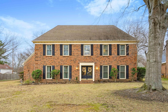 colonial inspired home featuring a front lawn