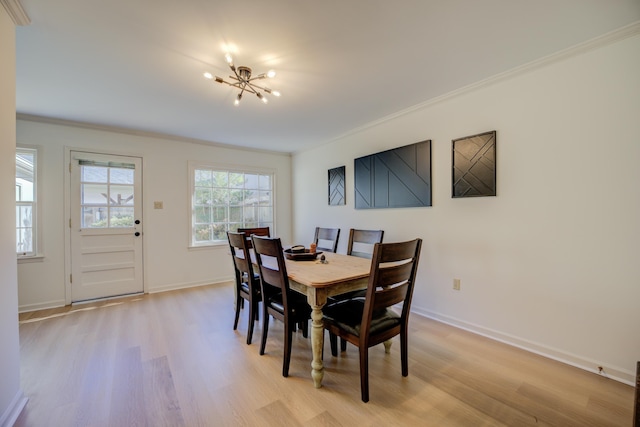 dining space with a chandelier, light wood-type flooring, and ornamental molding