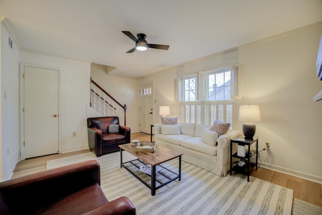 living room with ceiling fan, crown molding, and light hardwood / wood-style floors