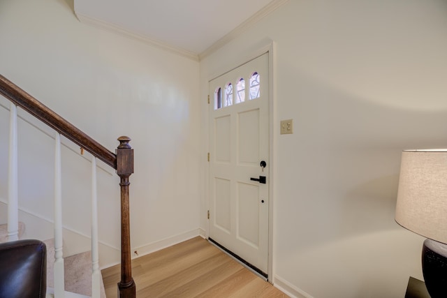 foyer entrance with light wood-type flooring and crown molding