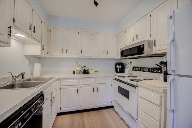 kitchen with sink, white cabinets, white appliances, and light hardwood / wood-style flooring