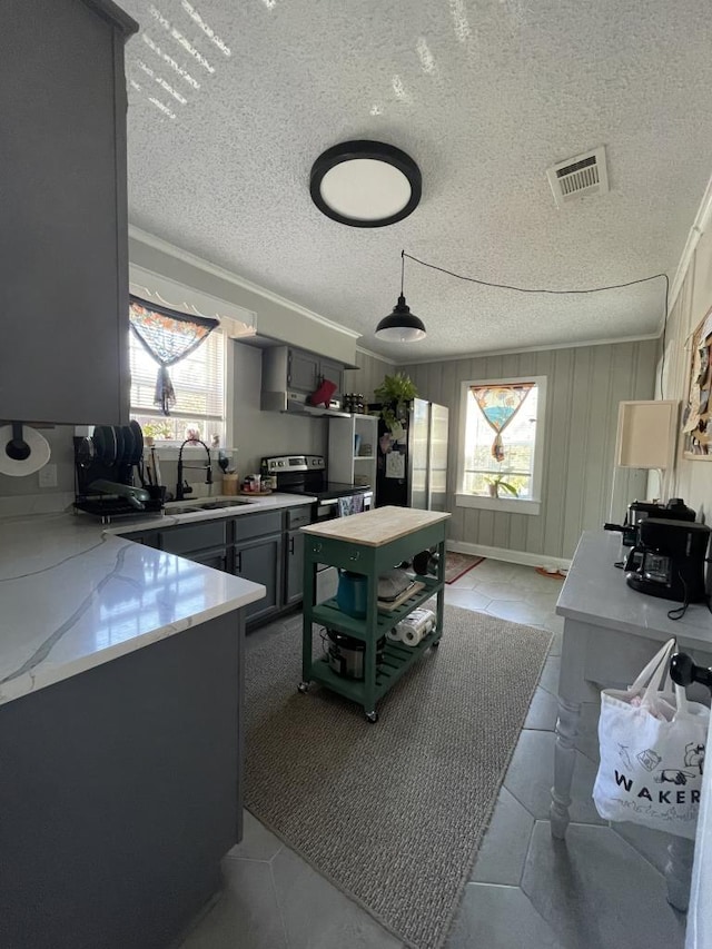 kitchen with sink, electric range, gray cabinets, light tile patterned floors, and a textured ceiling