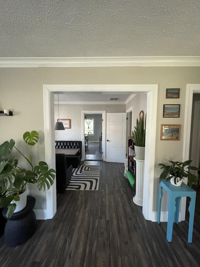 hallway featuring dark hardwood / wood-style flooring, ornamental molding, and a textured ceiling