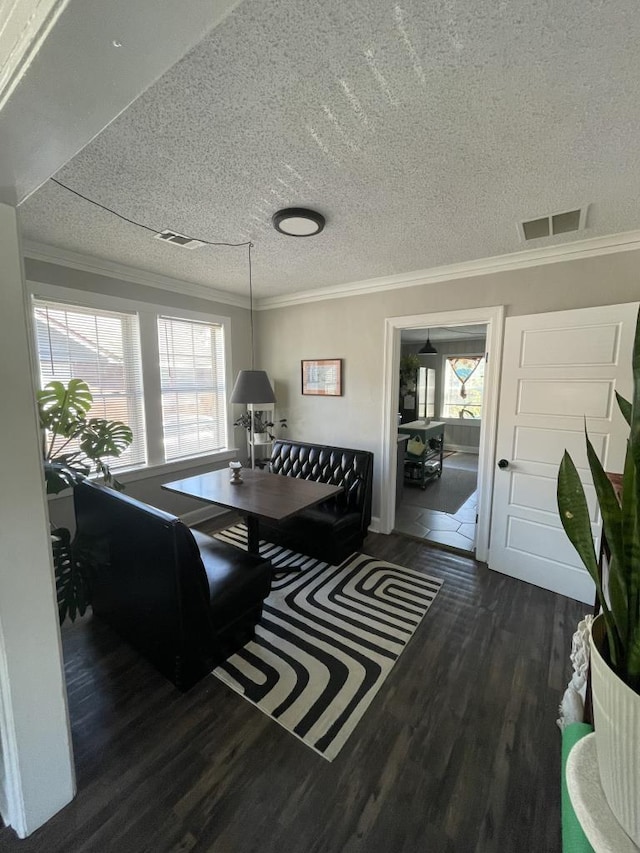 dining space featuring a textured ceiling, dark hardwood / wood-style floors, and ornamental molding