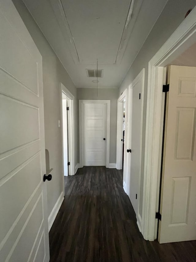 corridor with dark hardwood / wood-style flooring