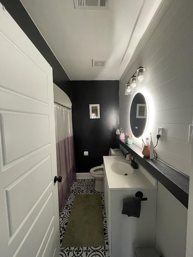 bathroom with tile patterned flooring, vanity, and toilet