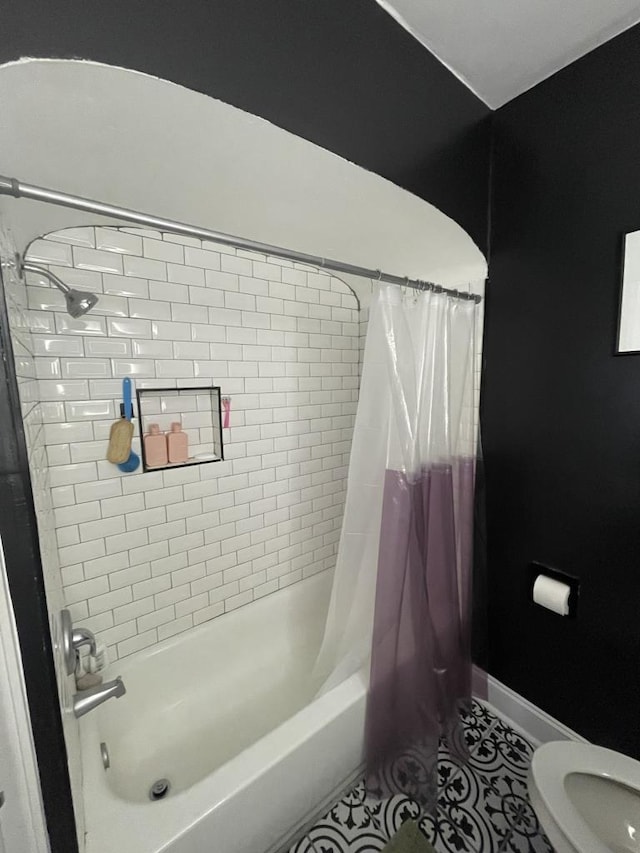 bathroom featuring tile patterned flooring, shower / bathtub combination with curtain, and toilet