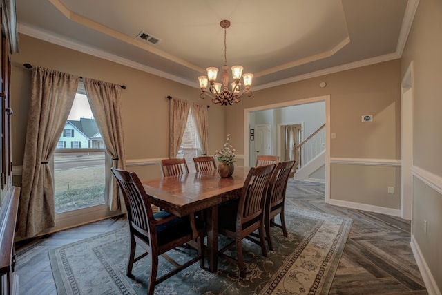 dining room featuring dark parquet floors, an inviting chandelier, crown molding, and a tray ceiling