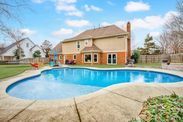 view of swimming pool with a patio and a trampoline