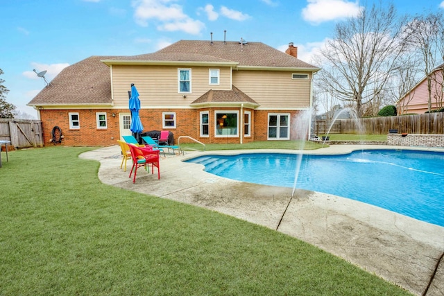 view of swimming pool with pool water feature, a yard, and a patio