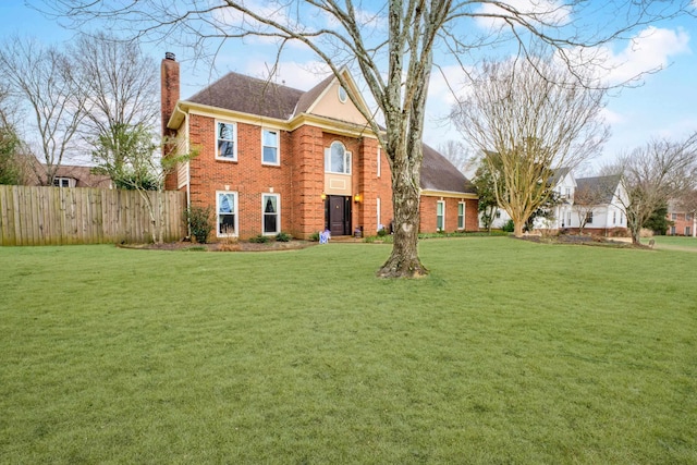 colonial-style house featuring a front yard